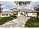 Stunning home with a three car garage, a gray tile roof, manicured lawn and a circular driveway at 2207 Cairns Ct, Orlando, FL 32835