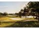 Picturesque golf course view with green fairway, serene lake, and mature trees on a sunny day at 2207 Cairns Ct, Orlando, FL 32835