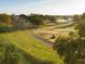 Aerial view of beautiful golf course with green grass, mature trees, walking path, and golf cart on a sunny day at 2207 Cairns Ct, Orlando, FL 32835