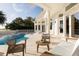 Covered outdoor patio overlooking the luxurious pool and verdant landscape at 2207 Cairns Ct, Orlando, FL 32835