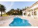 Backyard oasis with sparkling pool, palm trees, and manicured landscaping at 2207 Cairns Ct, Orlando, FL 32835