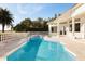 Inviting pool area with a spa, white columns, manicured landscaping, and a clear blue sky at 2207 Cairns Ct, Orlando, FL 32835