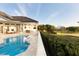 Backyard pool with adjacent golf course view, palm trees, and mature trees at 2207 Cairns Ct, Orlando, FL 32835