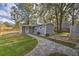 Landscaped yard featuring a stone walkway leading to a cozy firepit area and a fenced-in yard at 224 E Kelly Park Rd, Apopka, FL 32712