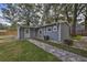 Backyard of a well-maintained house with a walkway leading to a fire pit and a fenced-in yard at 224 E Kelly Park Rd, Apopka, FL 32712