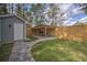 Backyard featuring a quaint shed and a covered outdoor kitchen area, all enclosed by a wooden fence at 224 E Kelly Park Rd, Apopka, FL 32712