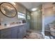 Modern bathroom featuring a gray vanity, vessel sink, round mirror, and a walk-in shower with glass door at 224 E Kelly Park Rd, Apopka, FL 32712