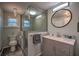 Updated bathroom with a glass-enclosed shower, gray vanity, round mirror, and modern fixtures at 224 E Kelly Park Rd, Apopka, FL 32712
