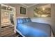 Cozy bedroom with a blue quilted bedspread, accent art, and a view into the adjacent living room at 224 E Kelly Park Rd, Apopka, FL 32712
