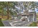 A tranquil backyard with a small bench in the patio area, complemented by lush trees and a wooden fence at 224 E Kelly Park Rd, Apopka, FL 32712