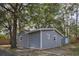 Quaint exterior showcasing a gray home with a well-manicured lawn, a privacy fence, and mature trees at 224 E Kelly Park Rd, Apopka, FL 32712