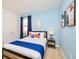 Bright bedroom painted in blue with abstract artwork, blue curtains, and white bedding at 2555 Shanti Dr, Kissimmee, FL 34746