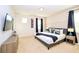 Modern bedroom features a large bed, dark curtains, and gray-striped accent wall at 2555 Shanti Dr, Kissimmee, FL 34746