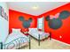Whimsical bedroom featuring twin beds, Mickey Mouse wall art, and playful decor at 2555 Shanti Dr, Kissimmee, FL 34746