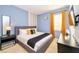 Stylish bedroom with modern decor, featuring a comfortable bed and bright orange curtains at 2555 Shanti Dr, Kissimmee, FL 34746