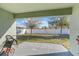 A covered patio overlooks the backyard, offering a peaceful view of the grassy area and white fenced perimeter at 2665 Rotherham Rd, Tavares, FL 32778