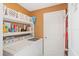Functional laundry room with a washer, dryer, shelving, and storage for cleaning supplies and laundry essentials at 2665 Rotherham Rd, Tavares, FL 32778