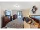 Comfortable main bedroom with a decorative bedspread, dresser, and TV, designed for relaxation at 2665 Rotherham Rd, Tavares, FL 32778