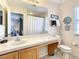 Bright bathroom with a large mirror, vanity with cabinets, and an adjacent toilet and shower at 2706 Bushman Dr, Kissimmee, FL 34746