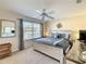 Comfortable bedroom with a ceiling fan, window with blinds, and neutral color scheme at 2706 Bushman Dr, Kissimmee, FL 34746