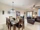 Open-concept dining area featuring tile flooring and a decorative chandelier over the table at 2706 Bushman Dr, Kissimmee, FL 34746