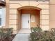 Welcoming front entrance featuring an arched porch, a tan exterior, and manicured landscaping at 2706 Bushman Dr, Kissimmee, FL 34746