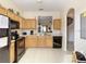 Efficient kitchen layout features wood cabinets, black appliances, and tile flooring for easy maintenance at 2706 Bushman Dr, Kissimmee, FL 34746