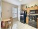 Efficient kitchen area with black appliances, light cabinets, and a dining area at 2706 Bushman Dr, Kissimmee, FL 34746