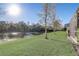 Backyard with a pond view, green grass, and mature trees at 2725 Econ Landing Blvd, Orlando, FL 32825