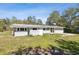 Quaint home featuring a light exterior, metal roof, and a well-maintained lawn, blending comfort and style at 27630 Jean Ave, Paisley, FL 32767