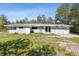 Wide view of a gray single-story home with metal roof and grassy yard at 27630 Jean Ave, Paisley, FL 32767