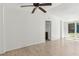 White living room and light wood flooring with an open door and sliding glass door at 27630 Jean Ave, Paisley, FL 32767