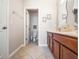 Bright bathroom features a wooden cabinet, a toilet in a separate room, and tile floors at 2979 Upper Park Rd, Orlando, FL 32814