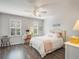 Cozy bedroom with white furnishings, ceiling fan, wood floors, and bright natural light at 2979 Upper Park Rd, Orlando, FL 32814