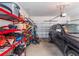 Cluttered garage featuring a parked SUV, storage shelves, and a rolling garage door at 2979 Upper Park Rd, Orlando, FL 32814