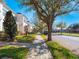 Street view of townhomes with mature trees lining the sidewalk on a sunny day, creating a serene and picturesque environment at 2979 Upper Park Rd, Orlando, FL 32814