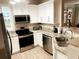 Bright kitchen features stainless steel appliances, white cabinets, and stylish countertops at 3000 Limbo Ln # 102, Kissimmee, FL 34746