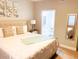 Bright bedroom showing en-suite bathroom, stylish mirror, queen bed, and wall decor at 3000 Limbo Ln # 102, Kissimmee, FL 34746