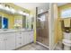 Bright bathroom showcasing double sinks, white cabinets, decorative mirrors, and a tiled walk-in shower at 3114 Meleto Blvd, New Smyrna Beach, FL 32168
