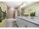 Bright bathroom featuring double sinks, granite countertop, tiled walls, and a shower-tub combo at 3114 Meleto Blvd, New Smyrna Beach, FL 32168