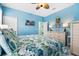 Comfortable bedroom with ceiling fan, coastal-themed bedding, and charming decorative artwork at 3114 Meleto Blvd, New Smyrna Beach, FL 32168