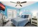Bright bedroom featuring a ceiling fan, cozy chair, and french doors with natural light at 3114 Meleto Blvd, New Smyrna Beach, FL 32168