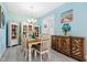 Charming dining room with wood table, decorative cabinets, and natural light from shuttered window at 3114 Meleto Blvd, New Smyrna Beach, FL 32168