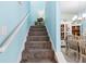 Carpeted stairway leads to a dining room with classic cabinets and chair rail at 3114 Meleto Blvd, New Smyrna Beach, FL 32168