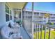 Enjoy the view from this screened-in balcony with charming wicker furniture and manicured lawn at 315 N Causeway # B302, New Smyrna Beach, FL 32169