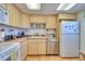 Efficient kitchen with white appliances, light wood cabinets, and ample counter space at 315 N Causeway # B302, New Smyrna Beach, FL 32169