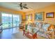 Bright living room with tropical-themed decor, slider to balcony and comfortable seating at 315 N Causeway # B302, New Smyrna Beach, FL 32169
