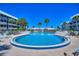 Community pool surrounded by lounge chairs, well maintained landscaping and sunny skies at 315 N Causeway # B302, New Smyrna Beach, FL 32169