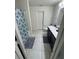 Clean bathroom with a single sink vanity, toilet, and a shower with a decorative curtain at 3166 Sweet Acres Pl, St Cloud, FL 34772
