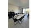 Bright dining area features a modern light fixture, a sleek white table with seating for six, and sliding glass doors to the exterior at 3166 Sweet Acres Pl, St Cloud, FL 34772